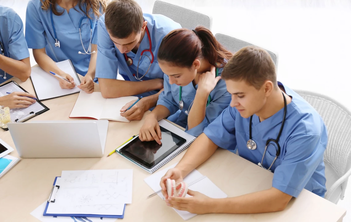 Fünf Medizinstudenten lernen gemeinsam an einem Tisch