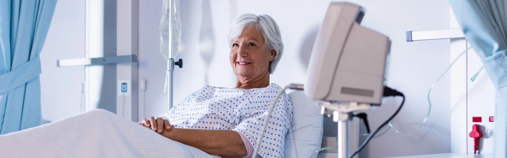 Eine ältere Patientin liegt in einem Krankernhauszimmer im Bett.