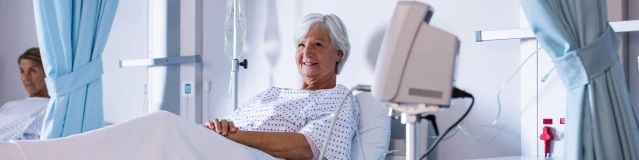 Eine ältere Patientin liegt in einem Krankernhauszimmer im Bett.