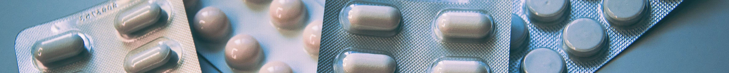 Vier Tablettenstreifen liegen verteilt auf einer Oberfläche.