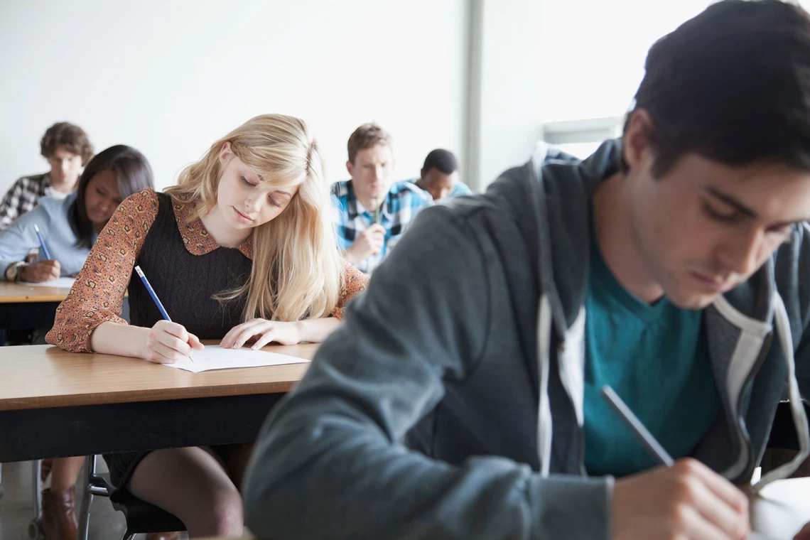 Mehrere Studenten sitzen in einer Prüfung.