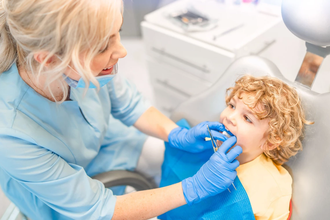 Eine Zahnärztin untersucht die Zähne eines Kindes.