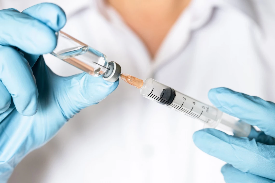 Eine Ärztin zieht eine Spritze in einer Impfdosis auf.