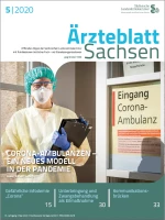 Person in medizinischer Schutzkleidung steht am Eingang einer Corona-Ambulanz