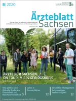 Mehrere Personen stehen neben einem Bus auf einer Grünfläche